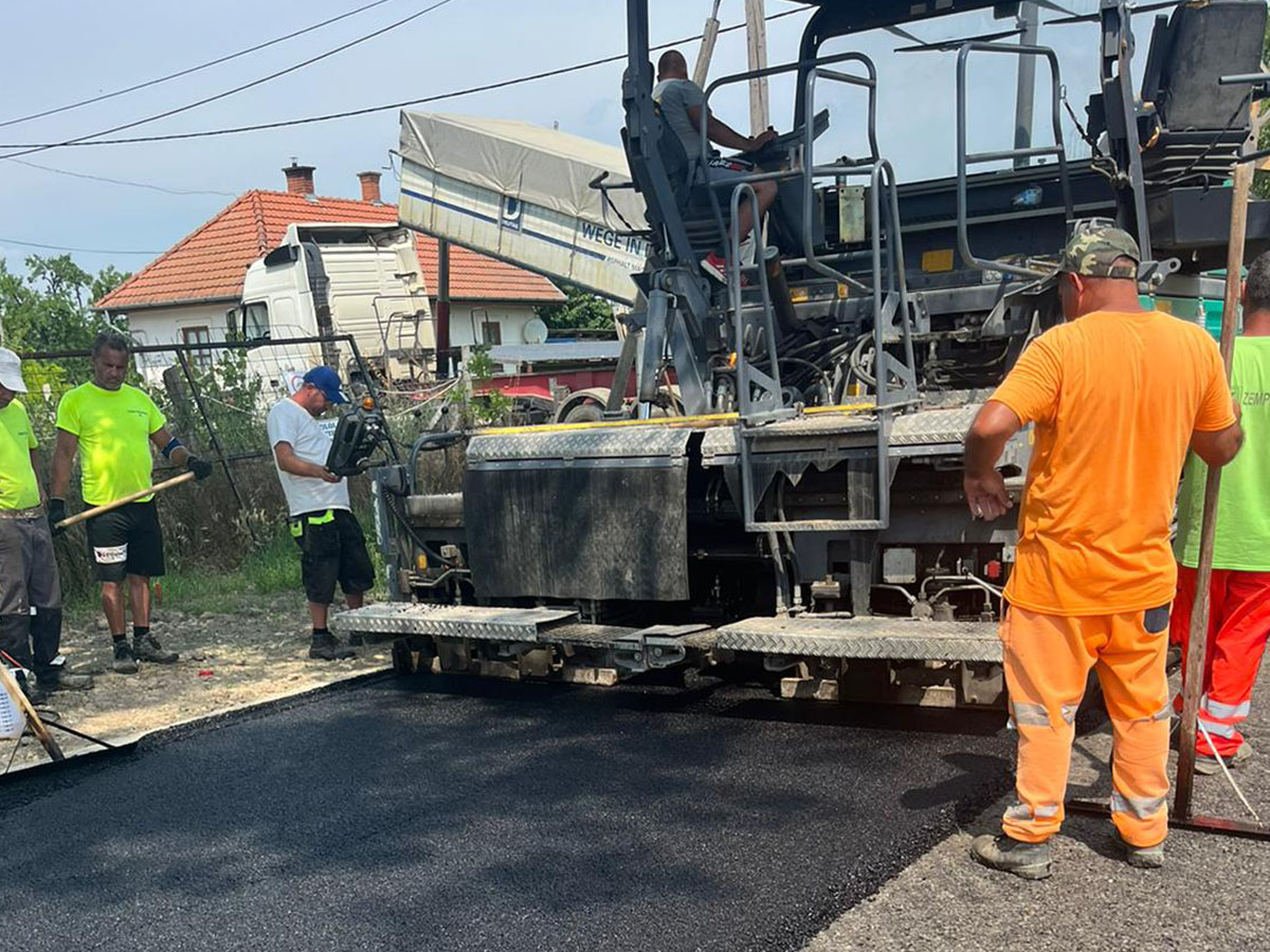 Aszfaltterítő finishergép és csapat munkában – HMA beépítés lakott területen