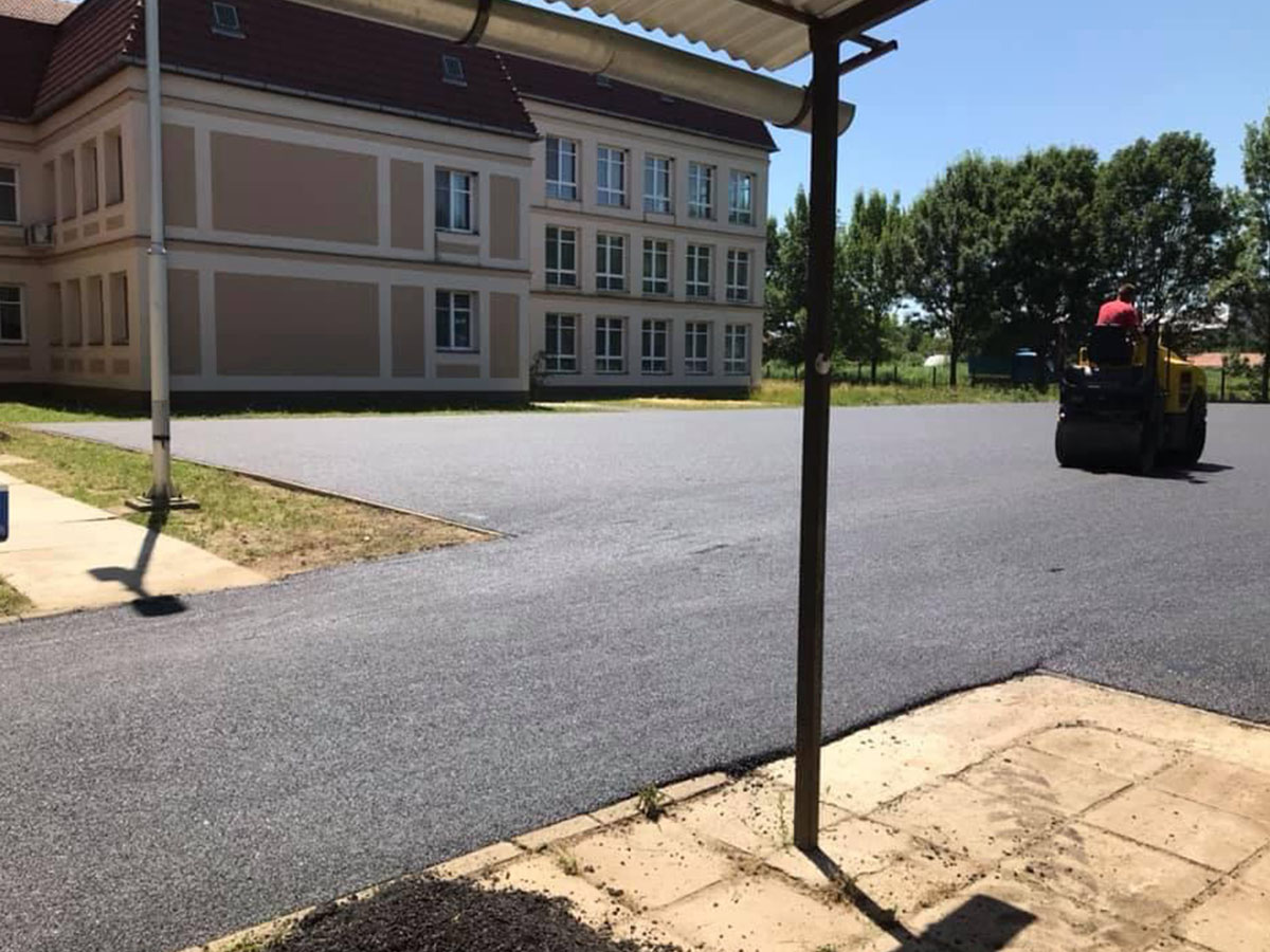 Iskola előtti parkoló és udvar aszfaltozása – hengerlés iskolaépület mellett